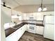 Bright kitchen with white cabinets, modern appliances, and dark countertops at 142 Long Leaf Pine Cir, Sanford, FL 32773