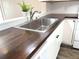 Close-up of the modern kitchen sink with stylish faucet and rich dark countertop at 142 Long Leaf Pine Cir, Sanford, FL 32773