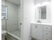 Bathroom showcasing new fixtures, glass shower, gray tile flooring, & a new white vanity at 1497 Jay St, Longwood, FL 32750