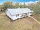 Aerial view of a charming single story home with a metal roof and a well manicured front yard with mature trees at 1510 Live Oak St, New Smyrna Beach, FL 32168