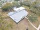 Aerial view of property, showcasing the well-maintained home, expansive metal roof, large lot, and surrounding trees at 1510 Live Oak St, New Smyrna Beach, FL 32168