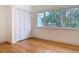 Bright bedroom featuring hardwood floors, a large window, and a closet with white shutter doors at 1510 Live Oak St, New Smyrna Beach, FL 32168