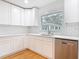 Bright kitchen featuring white cabinetry, stainless steel dishwasher and stylish backsplash at 1510 Live Oak St, New Smyrna Beach, FL 32168