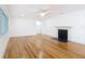 Spacious living room featuring gleaming hardwood floors, a ceiling fan, and an inviting fireplace with black tile at 1510 Live Oak St, New Smyrna Beach, FL 32168