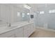 Bathroom boasts double sinks, white cabinets and a glass enclosed shower at 1511 Fairview Cir, Kissimmee, FL 34747