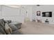 A modern living room with a gray couch, white chairs, and a mounted TV at 1511 Fairview Cir, Kissimmee, FL 34747