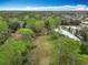 Aerial view showcasing a vast yard with a house and shed, complemented by mature trees and surroundings at 15523 Old Cheney Hwy, Orlando, FL 32828