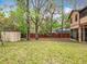 Lush backyard featuring mature trees, grass, and storage shed with a red fence bordering the rear property line at 15523 Old Cheney Hwy, Orlando, FL 32828