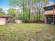 Spacious backyard featuring lush grass, mature trees, a shed and a covered patio area perfect for entertaining at 15523 Old Cheney Hwy, Orlando, FL 32828