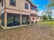 View of the backyard with a screened-in porch, lush landscaping, and large trees at 15523 Old Cheney Hwy, Orlando, FL 32828