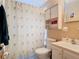 This bathroom features a toilet, vanity sink with storage, a medicine cabinet, and a shower with a palm tree-themed curtain at 15523 Old Cheney Hwy, Orlando, FL 32828