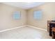 Neutral bedroom featuring tiled floors, 2 windows, and plain walls at 15523 Old Cheney Hwy, Orlando, FL 32828