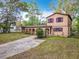 Inviting two-story home with a unique stucco facade, arched entry, and mature landscaping at 15523 Old Cheney Hwy, Orlando, FL 32828