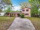 Inviting two-story home with a unique stucco facade, arched entry, and mature landscaping at 15523 Old Cheney Hwy, Orlando, FL 32828