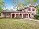 Inviting two-story home with a unique stucco facade, arched entry, and mature landscaping at 15523 Old Cheney Hwy, Orlando, FL 32828