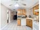 An open kitchen showcases wood cabinets, a ceiling fan, and flows seamlessly into the living area at 15523 Old Cheney Hwy, Orlando, FL 32828