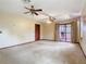 Open living room with ceiling fans, sliding glass doors, curtains, and wood-stained doors at 15523 Old Cheney Hwy, Orlando, FL 32828