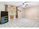 Well-lit living room with tile flooring, ceiling fan, and a front-facing window at 15523 Old Cheney Hwy, Orlando, FL 32828