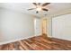 Bedroom with wood-look flooring, ceiling fan, and a view of the closet and hallway at 1582 Darlington Ave, Deltona, FL 32725