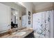 Cozy bathroom with a granite vanity, a framed mirror, and a shower with a blue floral curtain at 1726 Brackenhurst Pl, Lake Mary, FL 32746