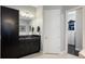 Bathroom featuring granite counters, dark cabinetry, and a doorway to the walk-in closet at 1726 Brackenhurst Pl, Lake Mary, FL 32746