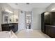 Spacious bathroom featuring double sinks, dark cabinets, granite counters, and tile flooring at 1726 Brackenhurst Pl, Lake Mary, FL 32746