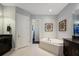 Bright bathroom with a soaking tub, granite counters, and neutral tile flooring at 1726 Brackenhurst Pl, Lake Mary, FL 32746