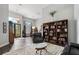 Spacious living room featuring a bookshelf, leather furnishings, and view of dining room at 1726 Brackenhurst Pl, Lake Mary, FL 32746