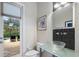 Stylish powder room featuring a glass sink, a mosaic tile wall, and access to patio at 1726 Brackenhurst Pl, Lake Mary, FL 32746