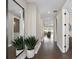 Bright hallway featuring hardwood floors, a modern mirror, potted plants, and a glimpse of the living area at 2030 Branched Oak Rd, St Cloud, FL 34771