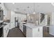 Modern kitchen featuring white cabinets, stainless steel appliances, a center island, and open access to staircase at 2030 Branched Oak Rd, St Cloud, FL 34771