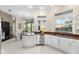 Well-lit kitchen with white cabinetry, stainless steel appliances, and a view of the backyard pool area at 235 Nob Hill Cir, Longwood, FL 32779