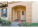 Inviting entryway with arched doorway, brick pathway, and a glimpse of the interior with view of the front door at 2511 Calabria Ave, Davenport, FL 33897