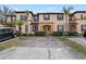 Townhome exterior with neutral tones, dark shutters, and well-maintained landscaping at 2511 Calabria Ave, Davenport, FL 33897