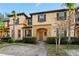 Neutral exterior of a townhome featuring an arched doorway and clean landscaping at 2511 Calabria Ave, Davenport, FL 33897