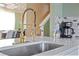 Close-up of the kitchen featuring a stainless steel sink, gold faucet and a view to the stairwell at 2511 Calabria Ave, Davenport, FL 33897