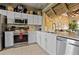 Kitchen featuring white cabinets, stainless steel appliances, marble countertops, and pirate themed decorations at 2511 Calabria Ave, Davenport, FL 33897