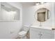 Clean, white bathroom with modern fixtures, including toilet, vanity, and a large mirror at 2570 Chatham Cir, Kissimmee, FL 34746