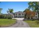 Beautifully landscaped property featuring a grand two-story home with mature trees, a paved driveway, and lush lawn at 3120 Downs Cove Rd, Windermere, FL 34786