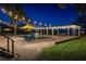 Lakeside swimming pool at night with string lights, pergola, and lounge chairs at 3120 Downs Cove Rd, Windermere, FL 34786