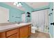 Bathroom featuring wood vanity, neutral countertop, coordinating walls, neutral floors, and decorative shower curtain at 3200 Utah Dr, Deltona, FL 32738