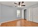 Bedroom featuring neutral walls, hardwood floors, closet, window, ceiling fan, and neutral trim at 3200 Utah Dr, Deltona, FL 32738