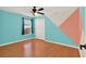 Bedroom featuring modern accent wall, ceiling fan, hardwood floors, closet, and neutral trim at 3200 Utah Dr, Deltona, FL 32738