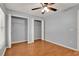 Bedroom featuring neutral walls, hardwood floors, two closets, window, ceiling fan, and neutral trim at 3200 Utah Dr, Deltona, FL 32738