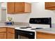 Close up of the electric stove and countertop featuring wooden cabinets and sleek countertops at 3200 Utah Dr, Deltona, FL 32738