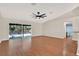 Relaxing living room features wood flooring, sliding glass doors to the pool area, and a view of the bathroom at 3200 Utah Dr, Deltona, FL 32738