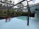 Pool with full screen cage and chairs, with a large deck and views of trees beyond at 3200 Utah Dr, Deltona, FL 32738