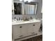 Bathroom featuring double vanity with white cabinets, black hardware, framed mirror, and neutral walls at 3220 Town And Country Rd, Oviedo, FL 32766