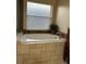 Large white bathtub with tile surround and a window view at 3220 Town And Country Rd, Oviedo, FL 32766