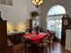 Formal dining room with elegant chandelier, complemented by a large arched window and classic furnishings at 3220 Town And Country Rd, Oviedo, FL 32766